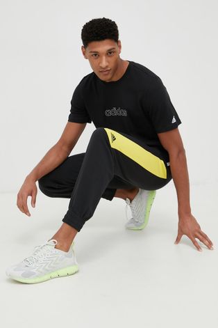 Памучна тениска adidas в черно с апликация