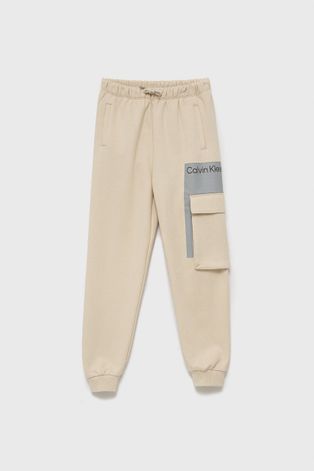 Dětské kalhoty Calvin Klein Jeans béžová barva, s potiskem