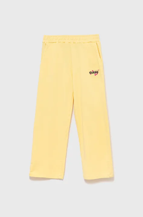 Guess spodnie dresowe dziecięce kolor żółty gładkie