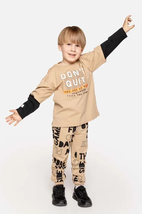 Детские хлопковые брюки Coccodrillo цвет бежевый с узором