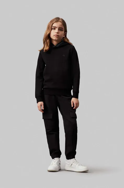 Otroški spodnji del trenirke Calvin Klein Jeans TERRY CARGO črna barva, IB0IB02121