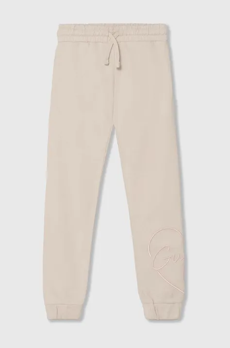 Детские хлопковые штаны Guess цвет бежевый с аппликацией J4YQ16 KA6R3