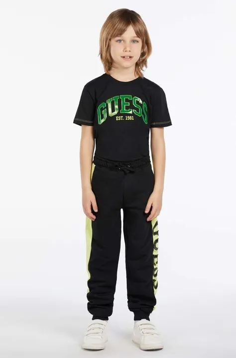 Дитячі бавовняні штани Guess колір чорний з аплікацією