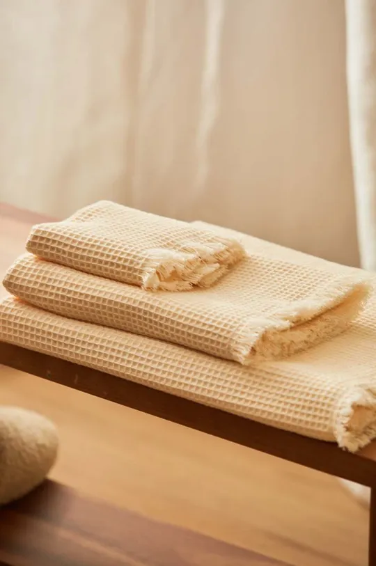 Malý bavlnený uterák Calma House Marte 30x50 cm béžová