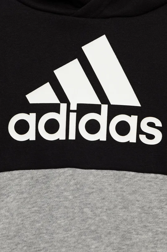 adidas gyerek együttes  Jelentős anyag: 70% pamut, 30% Újrahasznosított poliészter Kapucni bélés: 65% Újrahasznosított poliészter, 35% pamut Szegély: 95% pamut, 5% elasztán