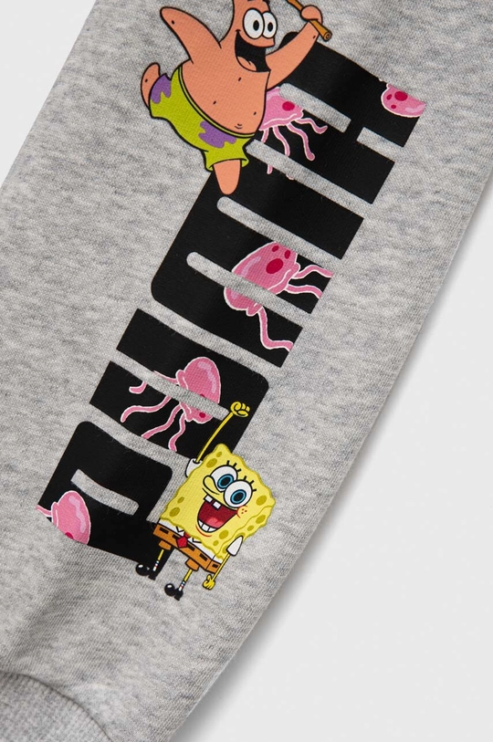 Otroški spodnji del trenirke Puma PUMA x SPONGEBOB Sweatpants TR  Glavni material: 68 % Bombaž, 32 % Poliester Podloga žepa: 100 % Bombaž Patent: 97 % Bombaž, 3 % Elastan