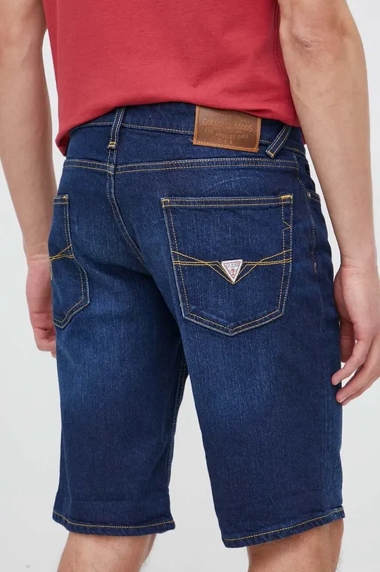 Jeans kratke hlače Guess  Glavni material: 65 % Bombaž, 34 % Lyocell, 1 % Elastan Podloga: 65 % Poliester, 35 % Bombaž