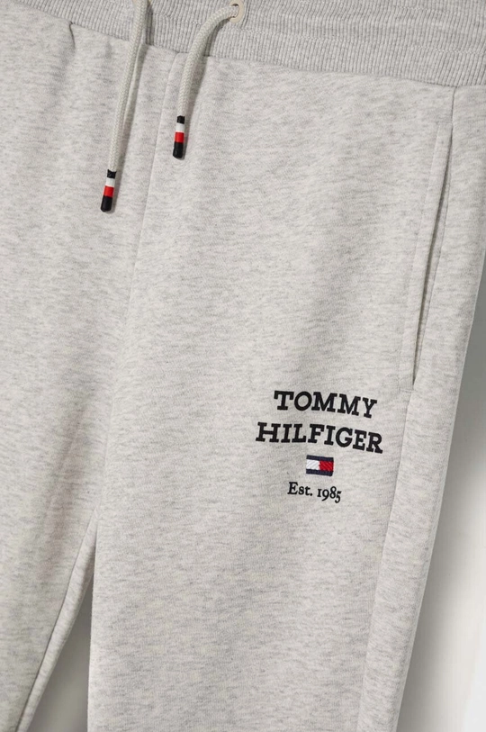 Otroški spodnji del trenirke Tommy Hilfiger Glavni material: 88 % Bombaž, 12 % Poliester Patent: 95 % Bombaž, 5 % Elastan