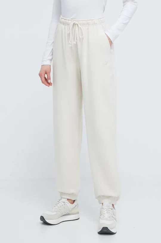 beżowy New Balance spodnie dresowe bawełniane WP41513LIN Damski