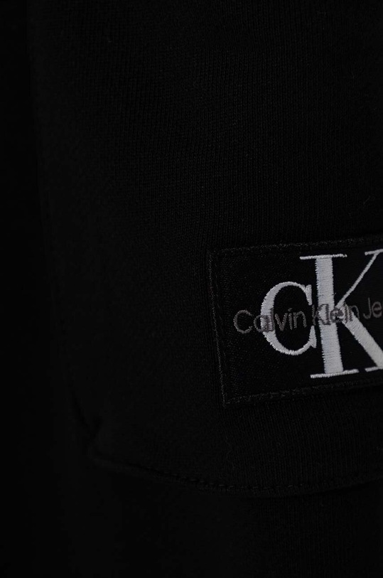 Chłopiec Calvin Klein Jeans spodnie dresowe bawełniane dziecięce BADGE CARGO RELAXED IB0IB02199.9BYH czarny