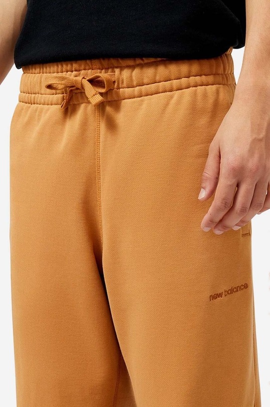 New Balance spodnie dresowe bawełniane pomarańczowy MP23551TOB