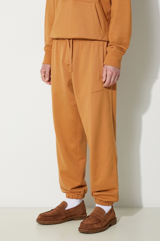 Bavlněné tepláky New Balance oranžová MP23551TOB