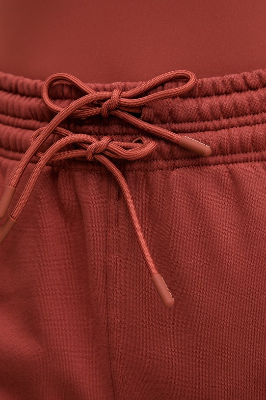 Бавовняні спортивні штани adidas by Stella McCartney помаранчевий JZ0660