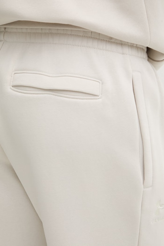 Under Armour spodnie dresowe męskie z bawełną Essential Fleece beżowy 1373882