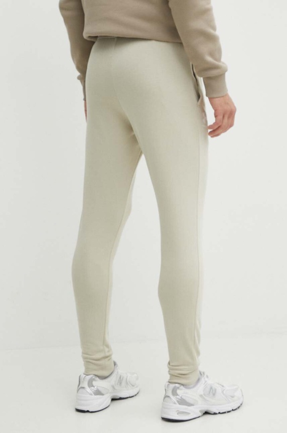 Odzież Under Armour spodnie dresowe 1380843 beżowy