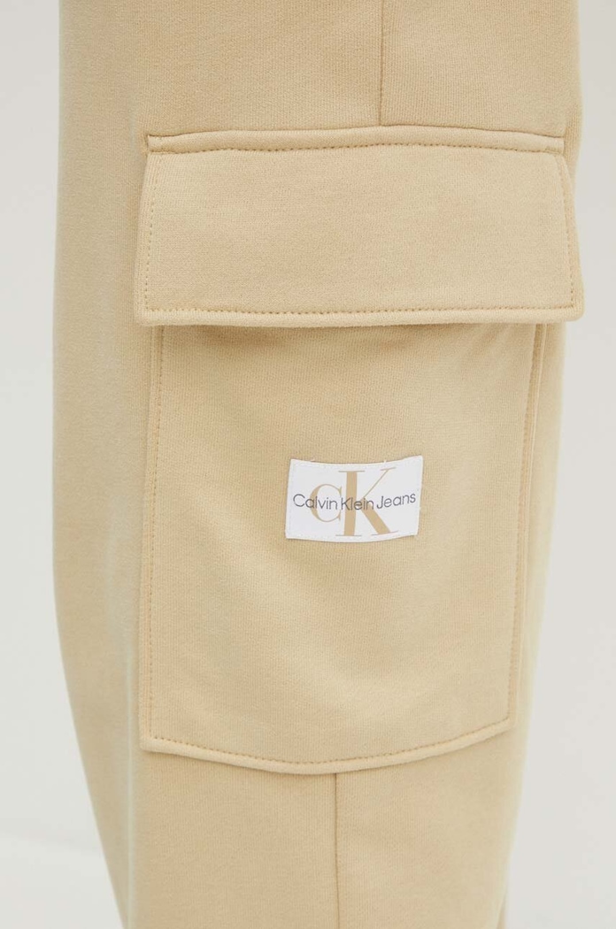 Bavlněné tepláky Calvin Klein Jeans béžová J20J223589