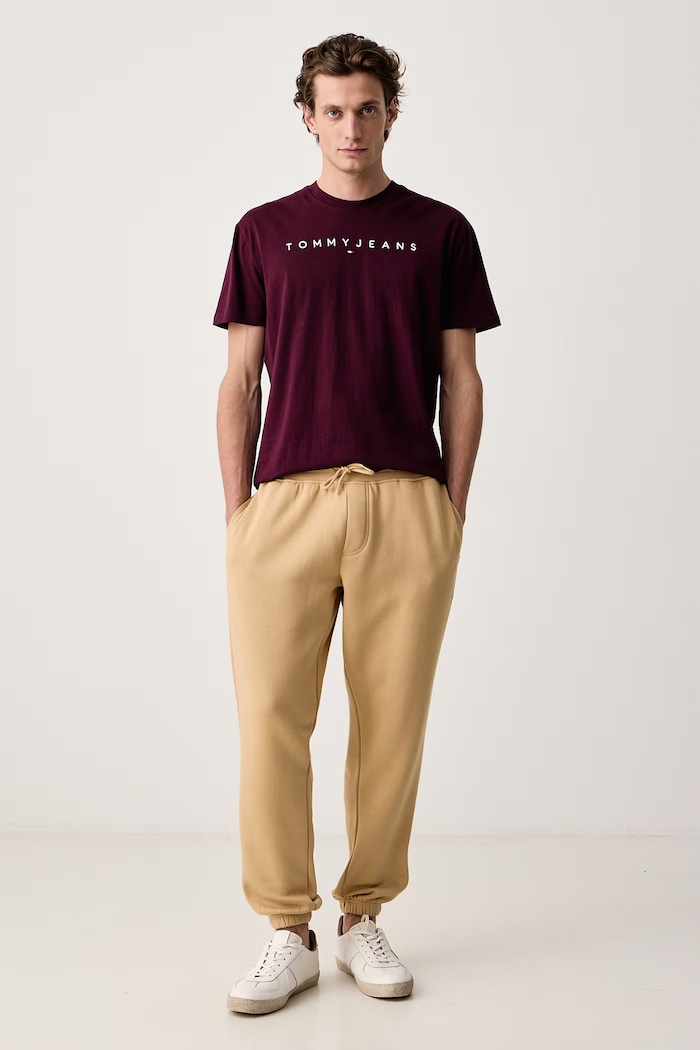 Tommy Jeans Tepláky pánské s bavlnou DM0DM20473 béžová SS26