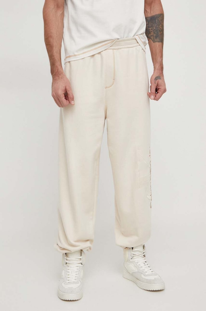 Bavlněné tepláky Calvin Klein Jeans béžová J30J324953