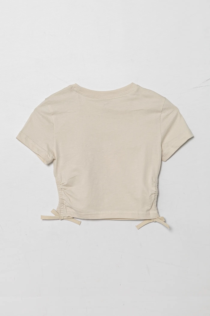 Puma t-shirt bawełniany dziecięcy FLAMING LOVE Knotted Tee 685108.G beżowy SS25