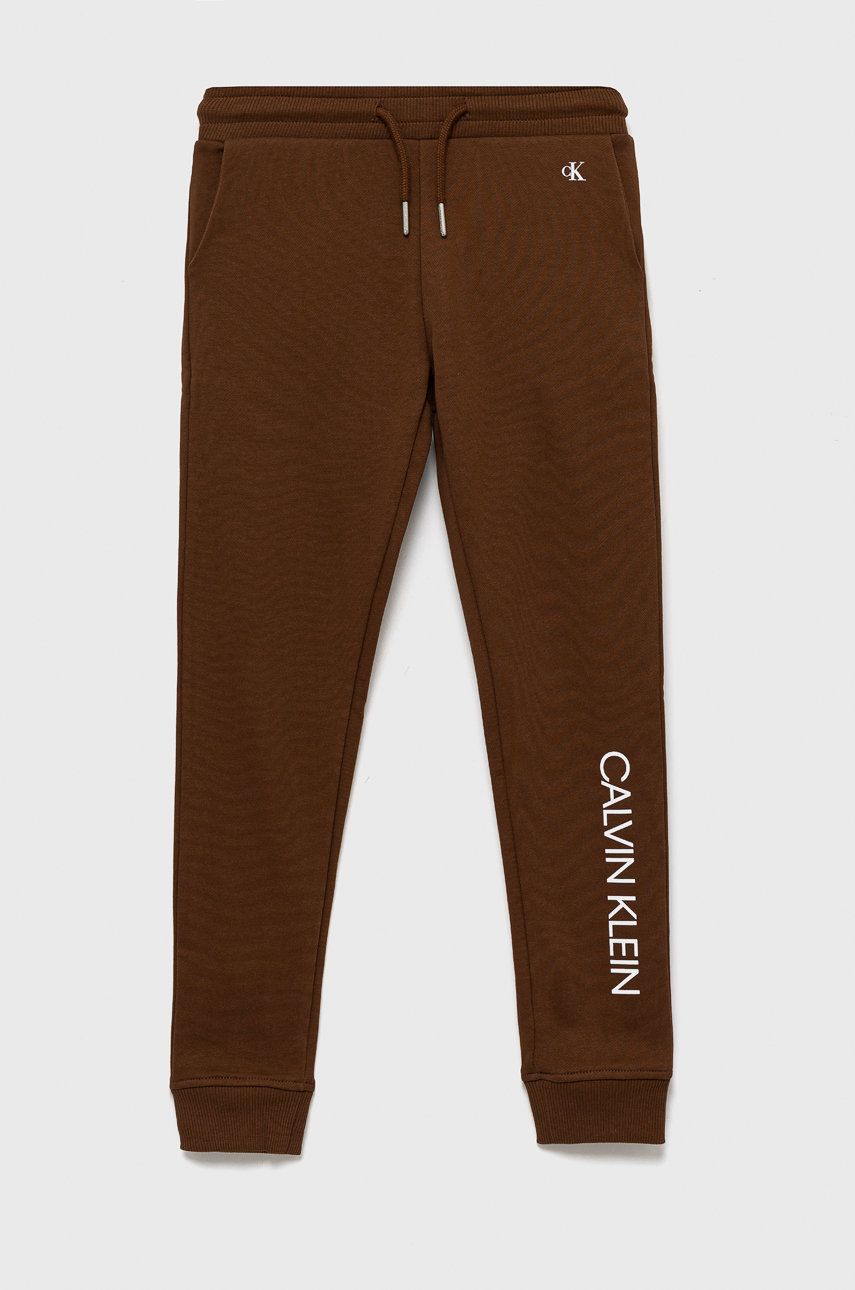 Calvin Klein Jeans spodnie dresowe bawełniane dziecięce kolor brązowy z nadrukiem