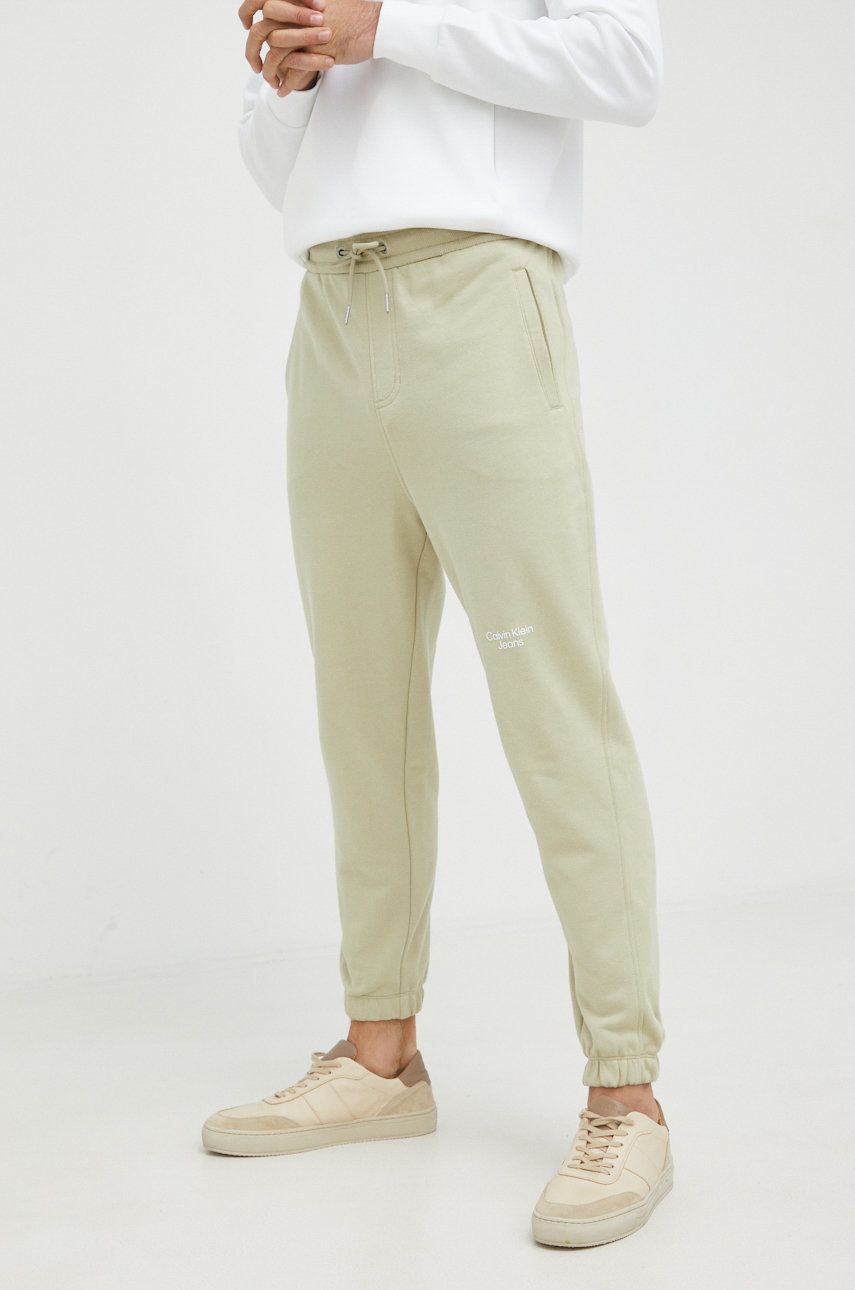 Bavlněné tepláky Calvin Klein Jeans zelená barva, s potiskem - zelená -  100% Bavlna