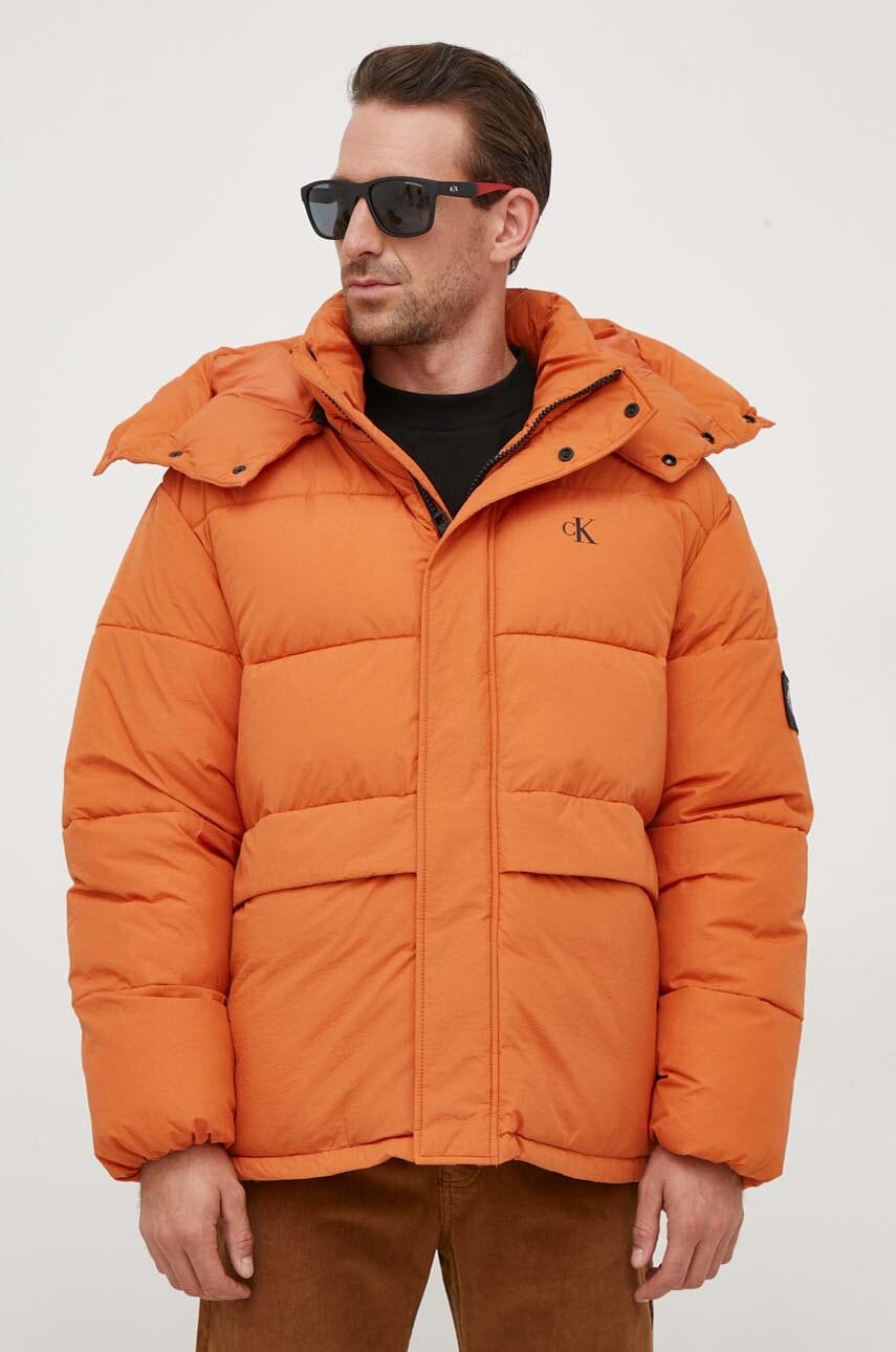 Levně Bunda Calvin Klein Jeans pánská, oranžová barva, zimní