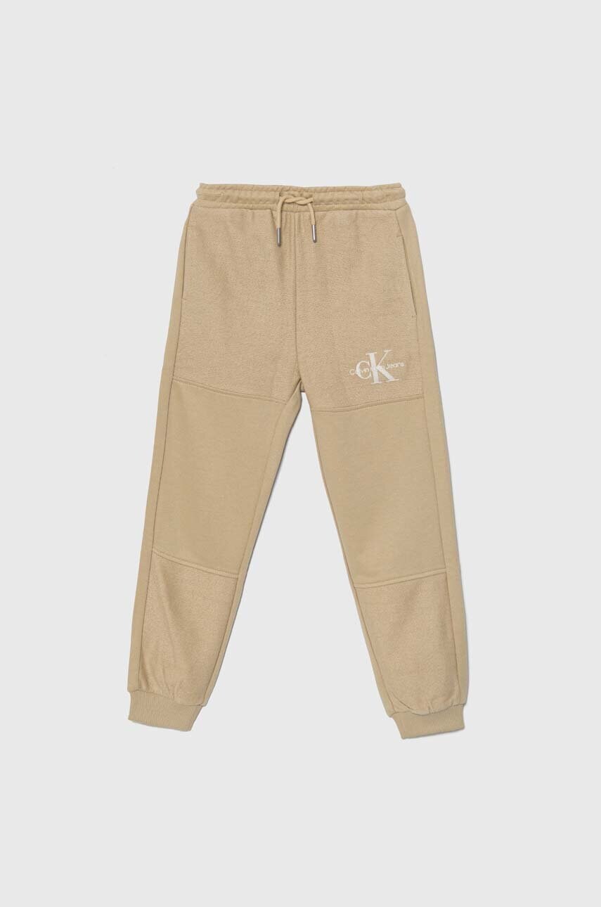 Levně Dětské tepláky Calvin Klein Jeans TERRY JOGGER béžová barva, hladké, IB0IB02119