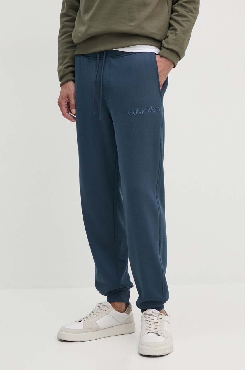 Levně Bavlněné tepláky Calvin Klein Jeans tmavomodrá barva, s potiskem, J30J326886