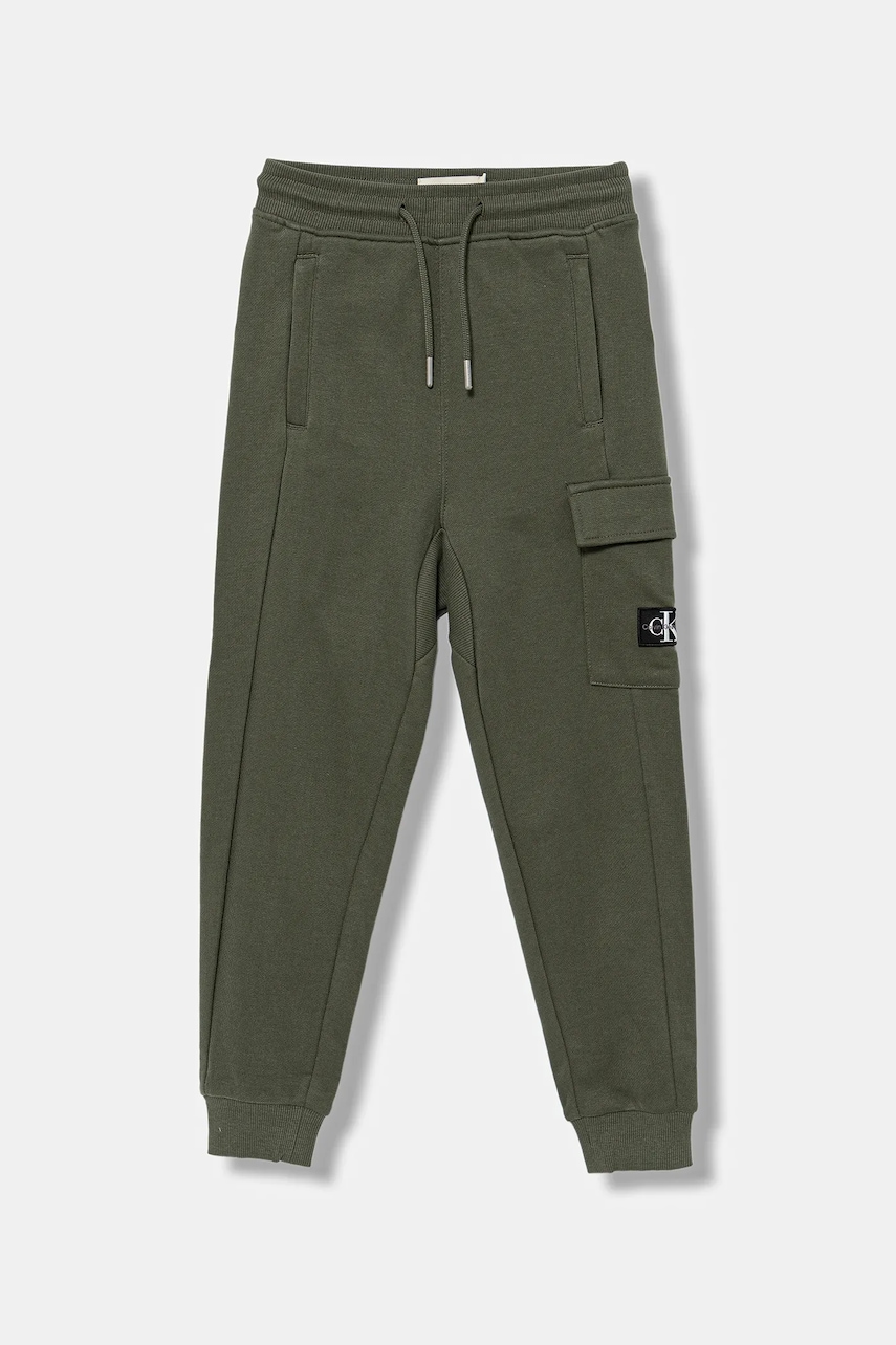 Levně Dětské bavlněné tepláky Calvin Klein Jeans zelená barva, IB0IB02199