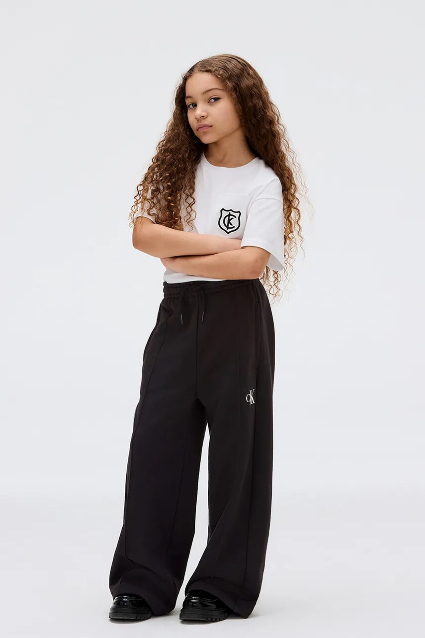 Levně Dětské tepláky Calvin Klein Jeans černá barva, s potiskem, IG0IG02875