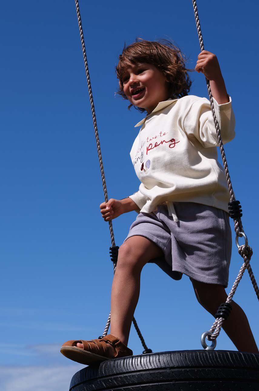 Levně Dětské bavlněné tričko s dlouhým rukávem Konges Sløjd béžová barva, s aplikací