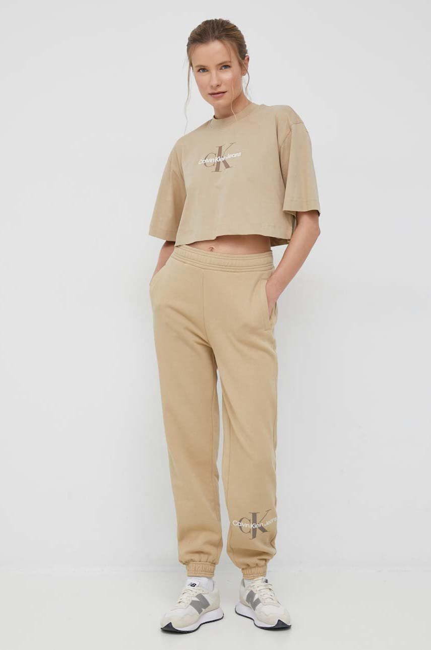 Levně Tepláky Calvin Klein Jeans dámské, béžová barva, s potiskem