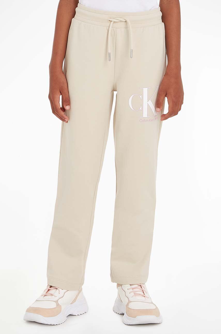 Levně Dětské tepláky Calvin Klein Jeans béžová barva, vzorované