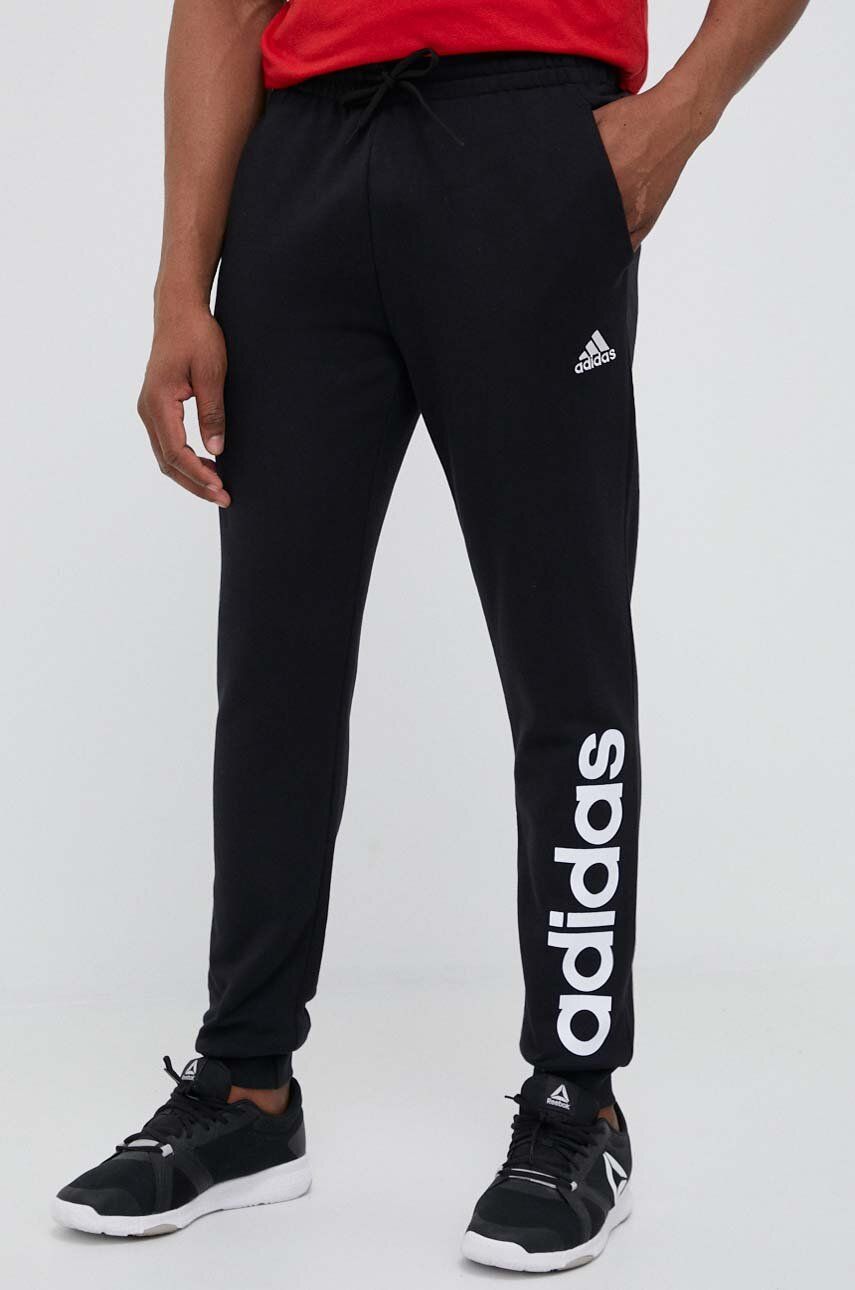 Levně Bavlněné tepláky adidas černá barva, s potiskem
