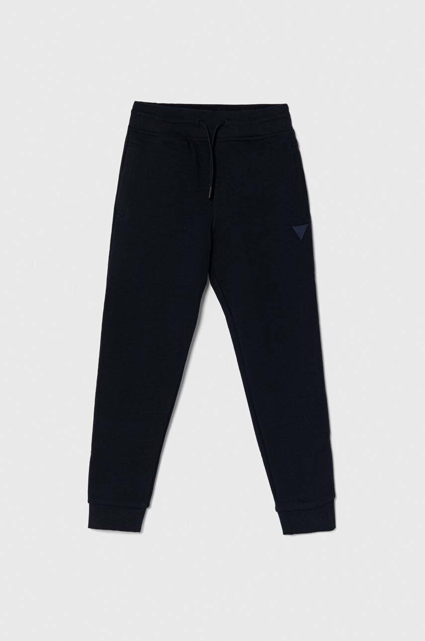 Levně Dětské tepláky Guess tmavomodrá barva, hladké
