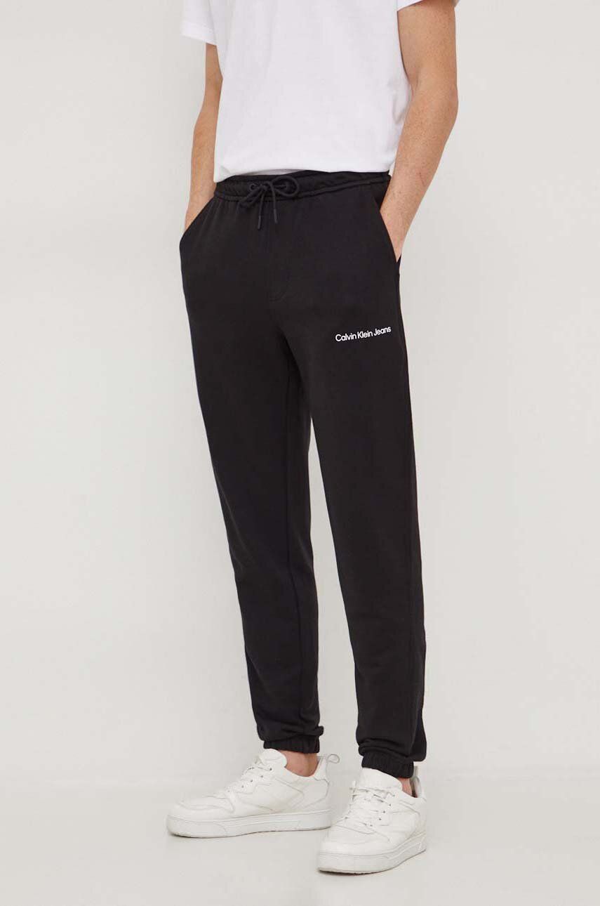 Levně Bavlněné tepláky Calvin Klein Jeans černá barva, J30J324739