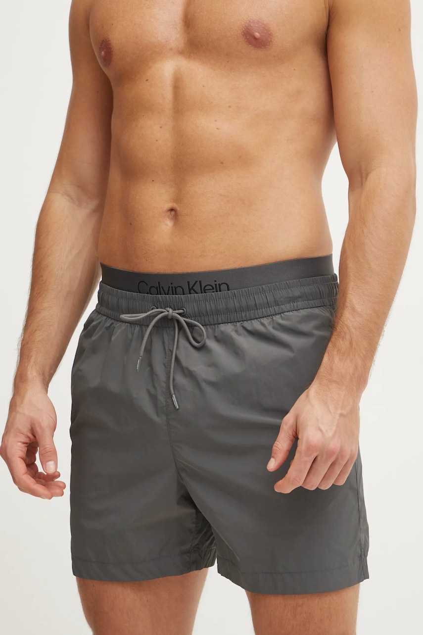 Levně Plavkové šortky Calvin Klein šedá barva, KM0KM01104