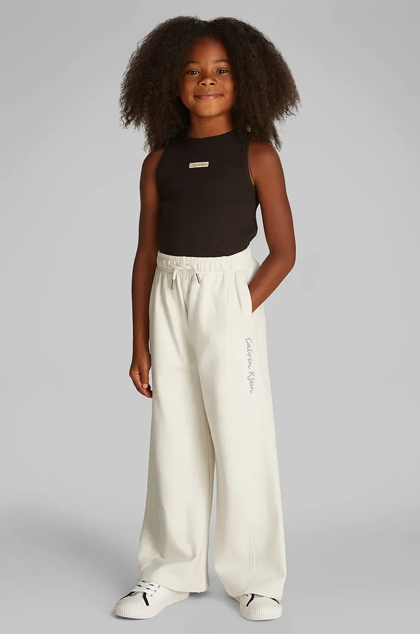 Levně Dětské tepláky Calvin Klein Jeans béžová barva, hladké, IG0IG02876