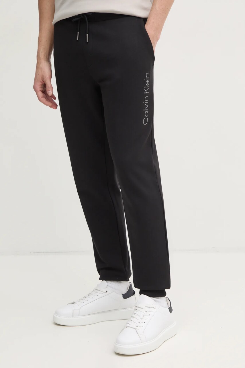 Levně Bavlněné tepláky Calvin Klein černá barva, s aplikací, K10K114254