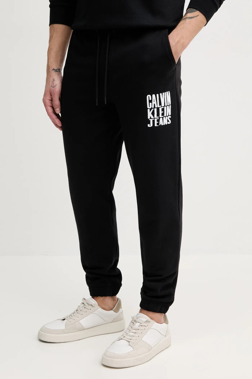Levně Bavlněné tepláky Calvin Klein Jeans černá barva, s potiskem, J30J327535