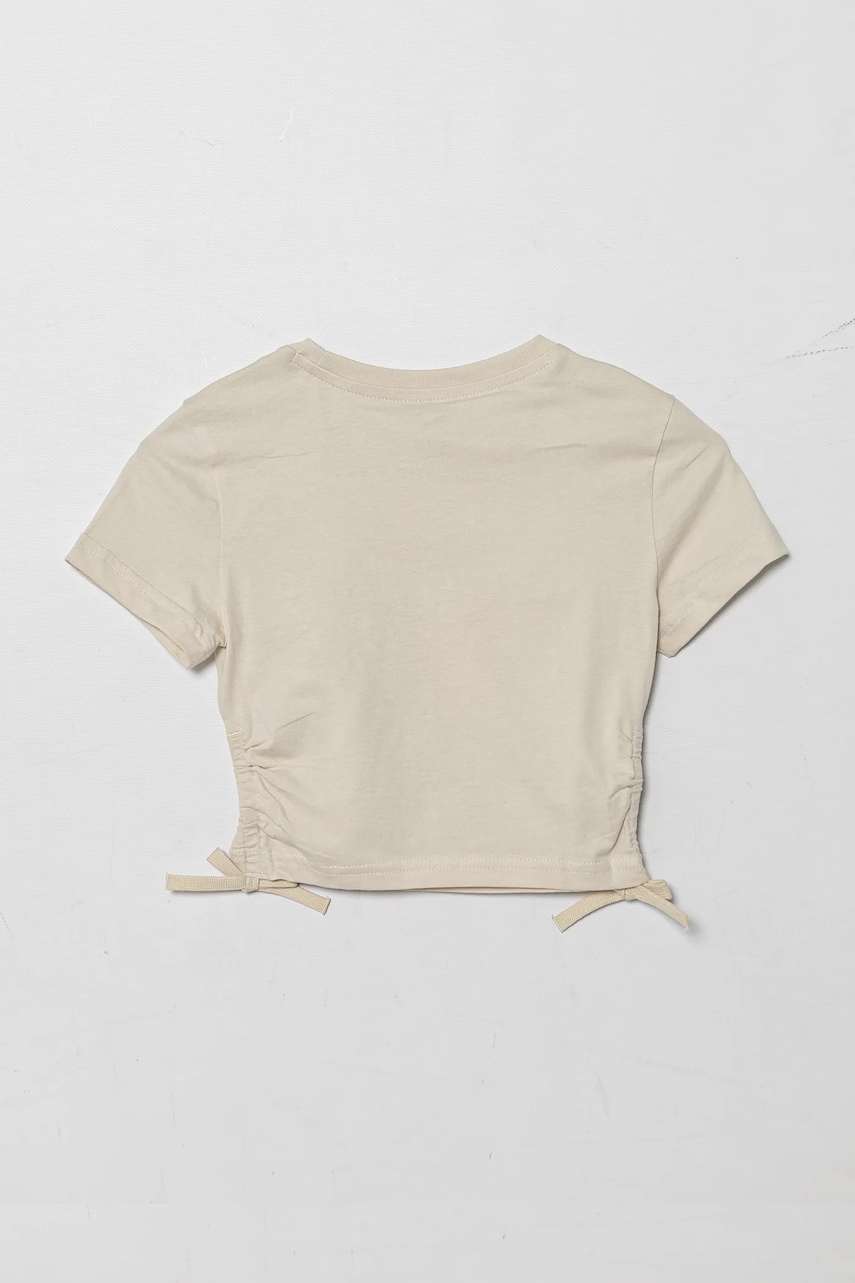 Детская хлопковая футболка Puma FLAMING LOVE Knotted Tee цвет бежевый 685108 Детская хлопковая футболка Puma FLAMING LOVE Knotted Tee цвет бежевый 685108